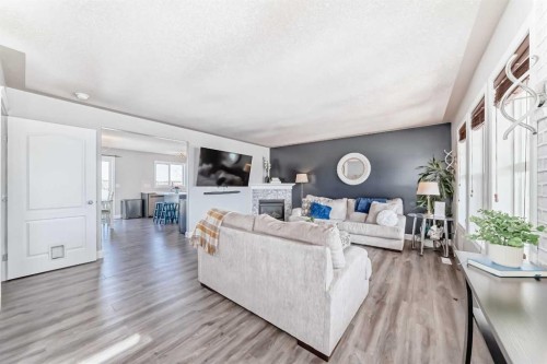 22 Moe Avenue Nw, Langdon, AB - Indoor Photo Showing Living Room With Fireplace