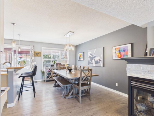 2049 New Brighton Gardens Se, Calgary, AB - Indoor Photo Showing Dining Room With Fireplace