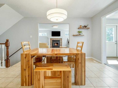 338 Deer Run Place West, Rural Lethbridge County, AB - Indoor Photo Showing Dining Room With Fireplace
