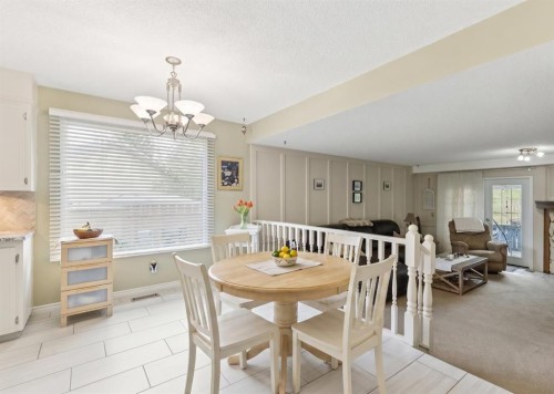 323 Ranchview Place Nw, Calgary, AB - Indoor Photo Showing Dining Room With Fireplace