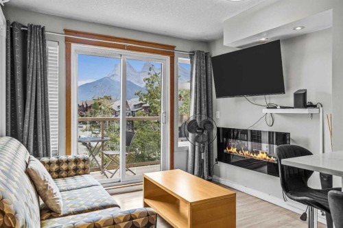 401-160 Kananaskis Way, Canmore, AB - Indoor Photo Showing Living Room With Fireplace