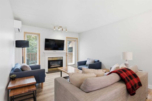 114-1720 Bow Valley Trail, Canmore, AB - Indoor Photo Showing Living Room With Fireplace