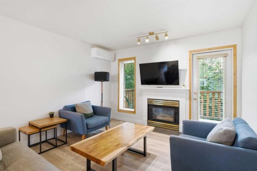 114-1720 Bow Valley Trail, Canmore, AB - Indoor Photo Showing Living Room With Fireplace
