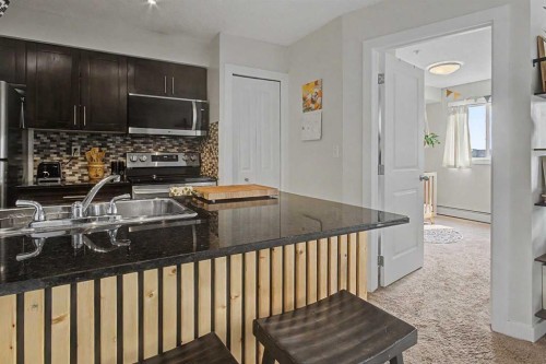 3407-403 Mackenzie Way Sw, Airdrie, AB - Indoor Photo Showing Kitchen With Double Sink