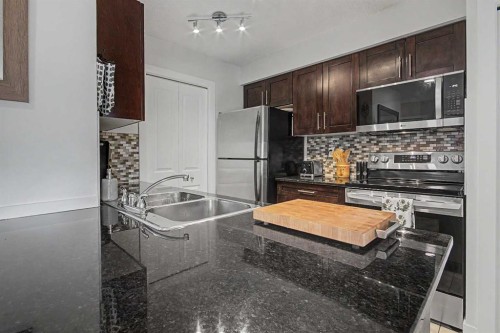3407-403 Mackenzie Way Sw, Airdrie, AB - Indoor Photo Showing Kitchen With Double Sink