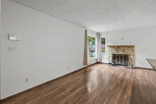 115 Mckenna Crescent Se, Calgary, AB - Indoor Photo Showing Living Room With Fireplace