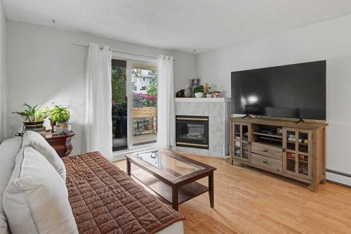 101-7724 Bowness Road Nw, Calgary, AB - Indoor Photo Showing Living Room With Fireplace