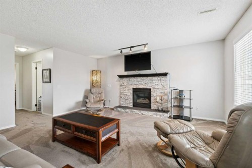 438 Sheep River Point, Okotoks, AB - Indoor Photo Showing Living Room With Fireplace