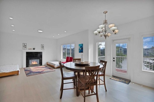 1125 Channelside Drive Sw, Airdrie, AB - Indoor Photo Showing Dining Room With Fireplace