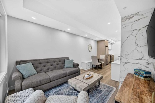 207-3450 19 Street Sw, Calgary, AB - Indoor Photo Showing Living Room With Fireplace