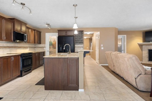 19 Silverado Skies Bay Sw, Calgary, AB - Indoor Photo Showing Kitchen With Fireplace