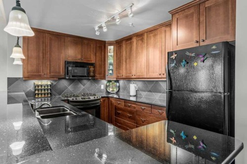 202-140 Stonecreek Road, Canmore, AB - Indoor Photo Showing Kitchen With Double Sink