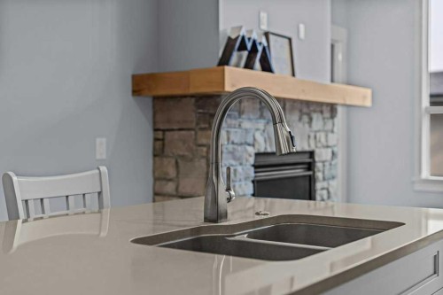 409-1105 Spring Creek Drive, Canmore, AB - Indoor Photo Showing Kitchen With Fireplace With Double Sink
