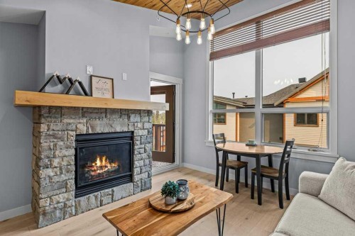 409-1105 Spring Creek Drive, Canmore, AB - Indoor Photo Showing Living Room With Fireplace