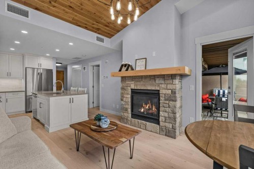 409-1105 Spring Creek Drive, Canmore, AB - Indoor Photo Showing Living Room With Fireplace