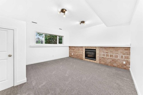 18 Julia Place, Didsbury, AB - Indoor Photo Showing Other Room With Fireplace