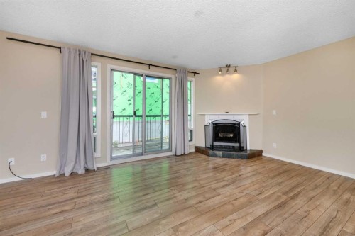 8-643 4 Avenue Ne, Calgary, AB - Indoor Photo Showing Living Room With Fireplace