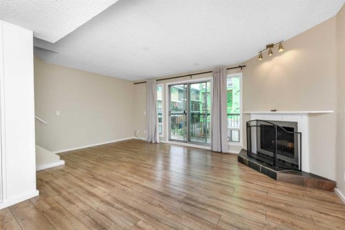 8-643 4 Avenue Ne, Calgary, AB - Indoor Photo Showing Other Room With Fireplace