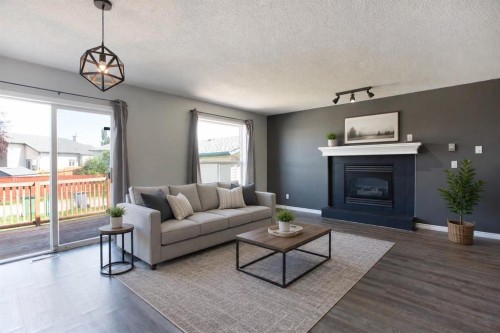 7269 Laguna Way Ne, Calgary, AB - Indoor Photo Showing Living Room With Fireplace