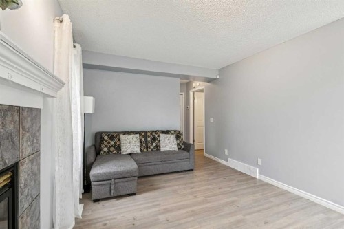 116 Quigley Close, Cochrane, AB - Indoor Photo Showing Living Room With Fireplace