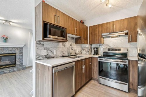 116 Quigley Close, Cochrane, AB - Indoor Photo Showing Kitchen With Fireplace With Stainless Steel Kitchen