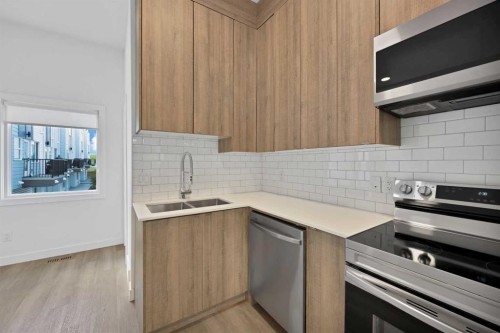 209-101 Panatella Square Nw, Calgary, AB - Indoor Photo Showing Kitchen With Double Sink With Upgraded Kitchen