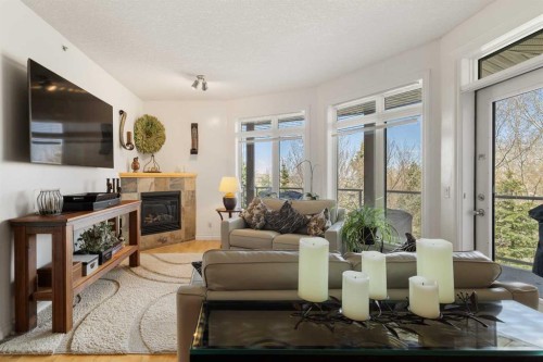 304-8 Hemlock Crescent Sw, Calgary, AB - Indoor Photo Showing Living Room With Fireplace