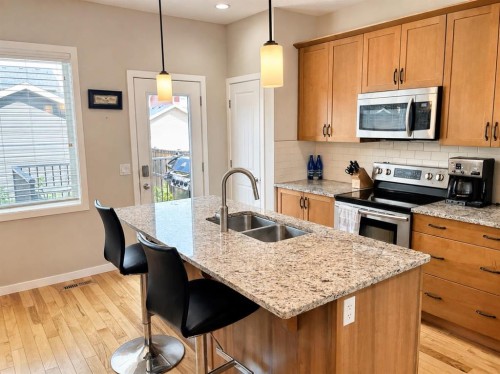 12 Fireside Bend, Cochrane, AB - Indoor Photo Showing Kitchen With Stainless Steel Kitchen With Double Sink With Upgraded Kitchen