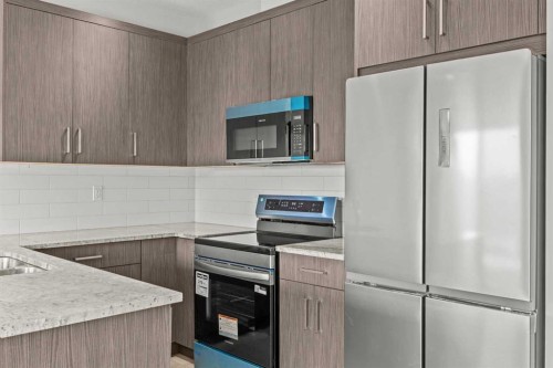 304 Jumping Pound Common, Cochrane, AB - Indoor Photo Showing Kitchen With Double Sink With Upgraded Kitchen