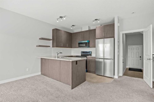304 Jumping Pound Common, Cochrane, AB - Indoor Photo Showing Kitchen With Stainless Steel Kitchen