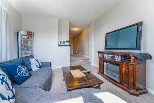 359 Sunrise View, Cochrane, AB - Indoor Photo Showing Living Room With Fireplace