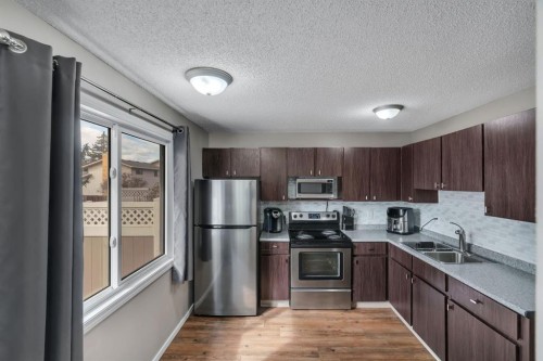 174 Woodmont Terrace Sw, Calgary, AB - Indoor Photo Showing Kitchen With Double Sink