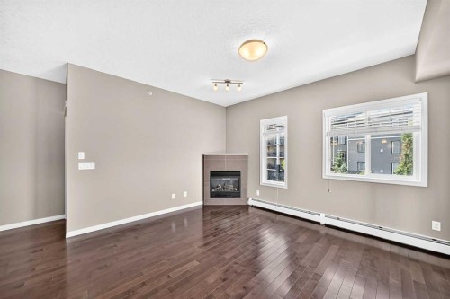 2401-175 Panatella Hill Nw, Calgary, AB - Indoor Photo Showing Other Room With Fireplace