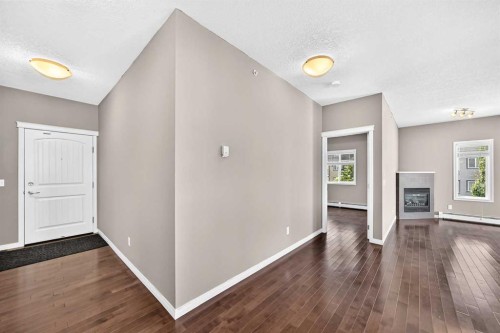 2401-175 Panatella Hill Nw, Calgary, AB - Indoor Photo Showing Other Room With Fireplace