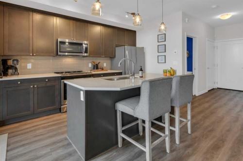 101-30 Shawnee Common Sw, Calgary, AB - Indoor Photo Showing Kitchen With Stainless Steel Kitchen With Double Sink With Upgraded Kitchen