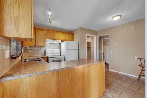 335 Queensland Drive Se, Calgary, AB - Indoor Photo Showing Kitchen With Double Sink
