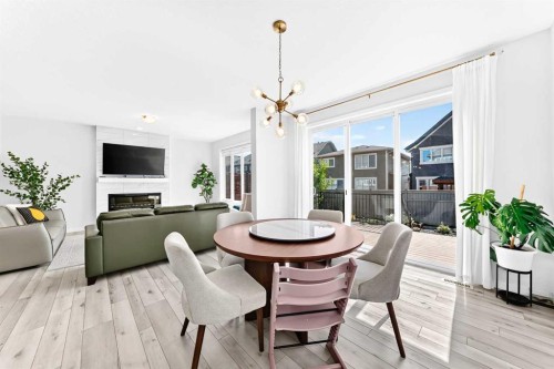 105 Magnolia Manor Se, Calgary, AB - Indoor Photo Showing Dining Room With Fireplace