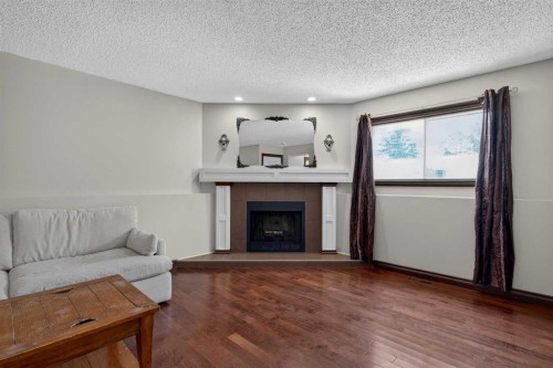 196 Suncrest Way Se, Calgary, AB - Indoor Photo Showing Living Room With Fireplace