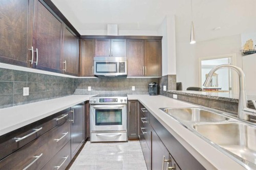3104-15 Sunset Square, Cochrane, AB - Indoor Photo Showing Kitchen With Double Sink With Upgraded Kitchen