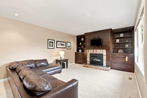 70 Sunset Way Se, Calgary, AB - Indoor Photo Showing Living Room With Fireplace