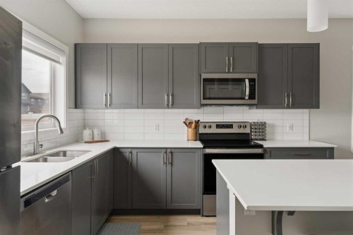 12 Wolf Creek Drive Se, Calgary, AB - Indoor Photo Showing Kitchen With Stainless Steel Kitchen With Double Sink With Upgraded Kitchen
