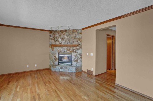 62 West Mitford Crescent, Cochrane, AB - Indoor Photo Showing Other Room With Fireplace