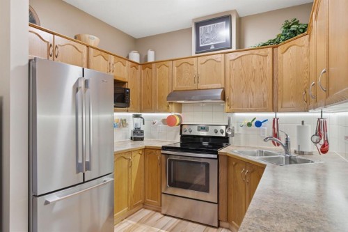 207-72 Quigley Drive, Cochrane, AB - Indoor Photo Showing Kitchen With Double Sink