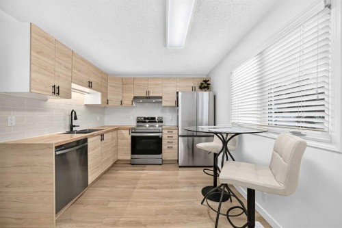 135 Woodsman Lane Sw, Calgary, AB - Indoor Photo Showing Kitchen With Double Sink