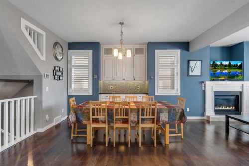 353 Kinniburgh Boulevard, Chestermere, AB - Indoor Photo Showing Dining Room With Fireplace